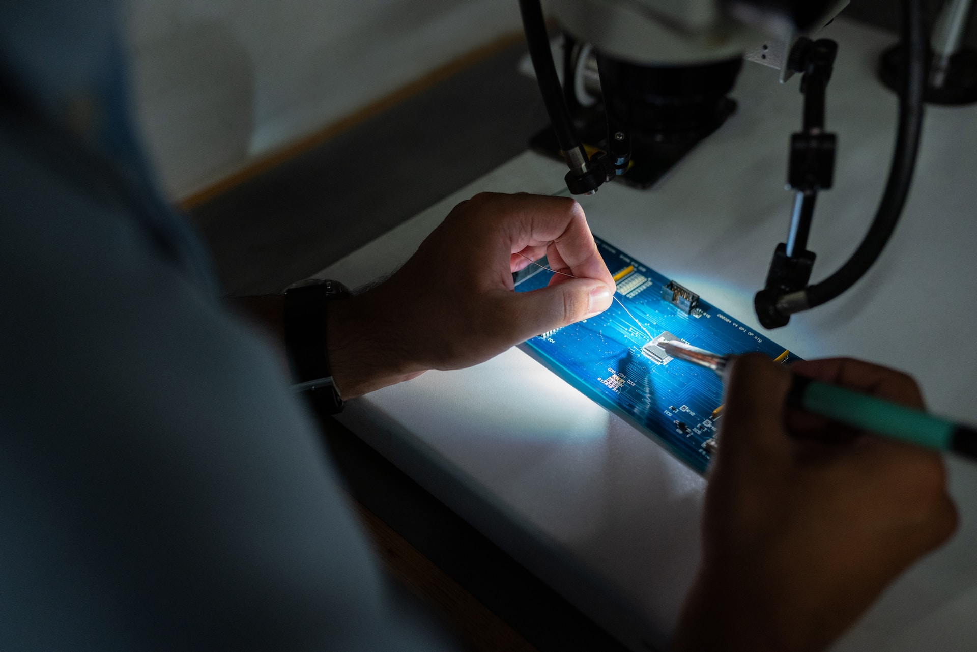 person soldering a printed circuit board