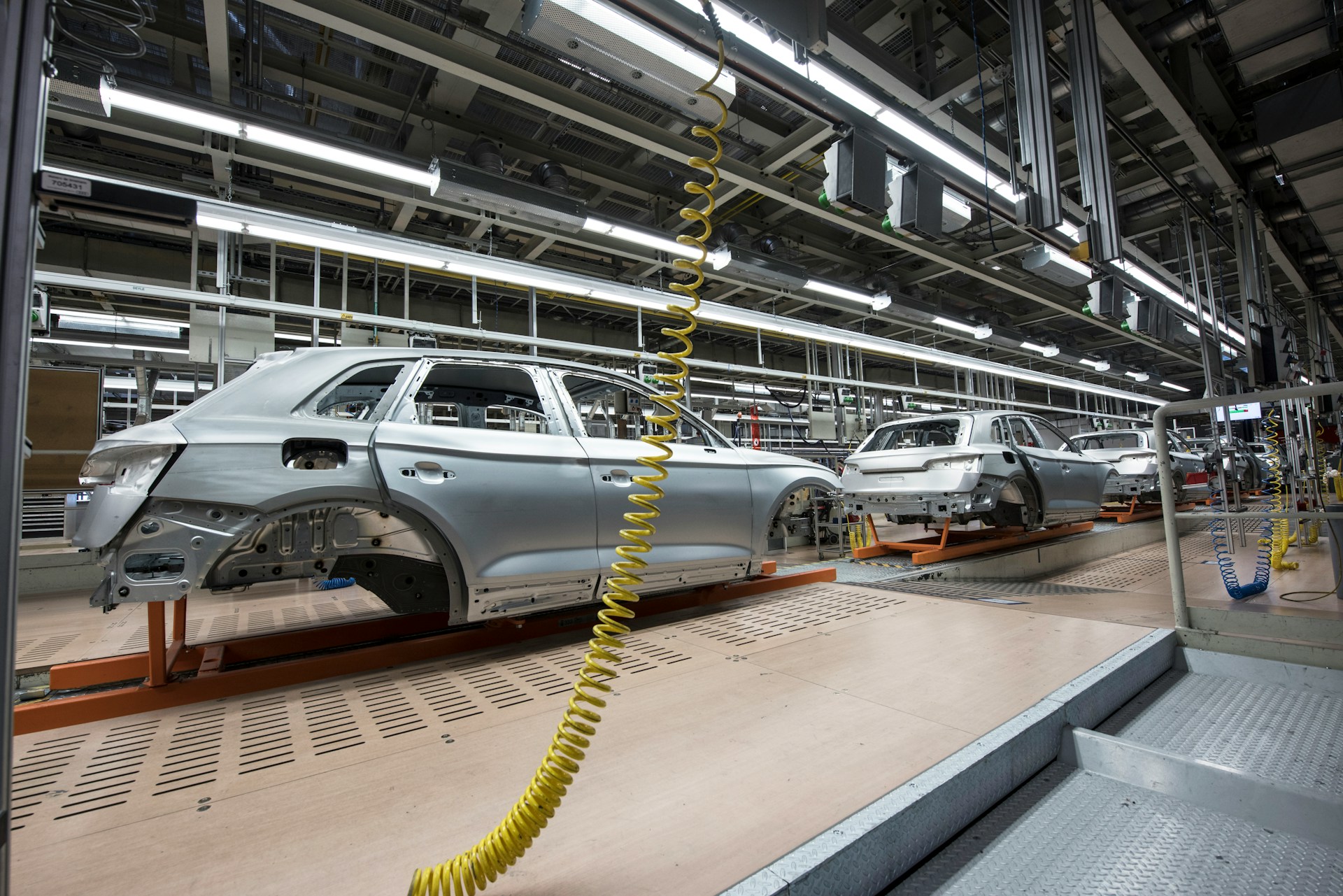 silver car in pieces on an assembly line